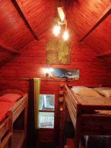 sypialnia z 2 łóżkami w drewnianym domku w obiekcie La Cabane du Raideur w mieście Cilaos