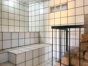 a room with white tiled walls and a shelf at Analândia - Recreio dos Netos in Analândia