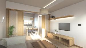 a living room with a couch and a tv on a wall at Elafonisi Resort by Kalomirakis Family in Elafonisi
