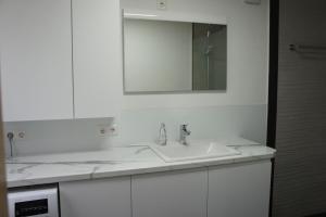 a white bathroom with a sink and a mirror at Ferienwohnung Martin in Neuhausen ob Eck