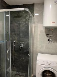um chuveiro na casa de banho com uma máquina de lavar roupa em Apartman A2 em Ulcinj