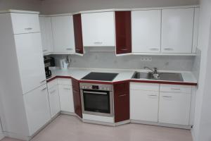 a small kitchen with white cabinets and a sink at Ferienwohnung Martin in Neuhausen ob Eck