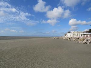 a beach with rocks and a blue sky and clouds at gite repos et tranquillité P in Cayeux-sur-Mer
