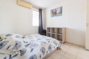 sypialnia z łóżkiem z niebiesko-białą kołdrą w obiekcie T2 Tt Confort/Wifi 200m plages Anses Mitan 3 Ilets w mieście Les Trois-Îlets