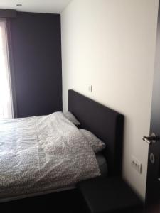 a bedroom with a bed with a black headboard at Apartment Mauritius in Knokke-Heist