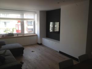 a living room with a couch and a tv on a wall at Apartment Mauritius in Knokke-Heist