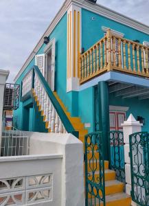 a blue house with stairs in front of it at Turquoise B&B in Willemstad