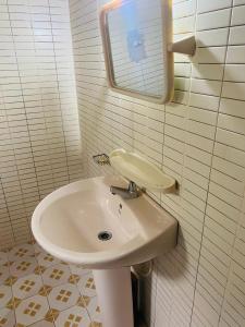 y baño con lavabo blanco y espejo. en Chandi Gaya Beach Guesthouse, en Tangalle
