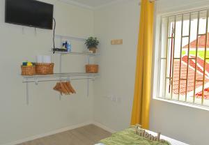 a room with a tv and shelves on the wall at Turquoise B&B in Willemstad