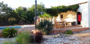 uma casa com um deque ao lado de uma piscina em Rural Peace in the Algarve - Private Room with kitchenette and bathroom em Aldeia dos Matos