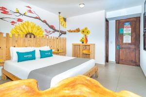 1 dormitorio con 1 cama blanca grande con almohadas azules en Ayenda Jardin de Provenza en Medellín