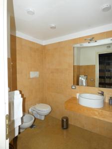 a bathroom with two toilets and a sink and a mirror at Resort CostantiNapoli 27 in Naples +20 photos