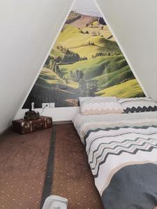 um quarto com uma cama e um quadro na parede em Cabana Samira 1 em Tăşnad