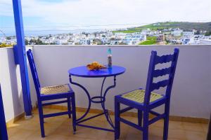 d'une table bleue et de deux chaises sur un balcon. dans l'établissement Serene Hill, à Náoussa