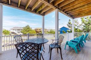 a patio with a table and chairs on a deck at Seaside - Silver Lining 202B in Virginia Beach