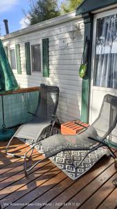 dos sillas sentadas en una terraza frente a una casa en Mobil Home Hyères les palmiers, en Hyères