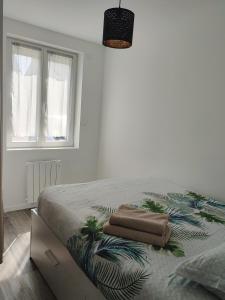 1 dormitorio con 1 cama con 2 toallas en Joli appartement avec jardin-terrasse privé en Brest