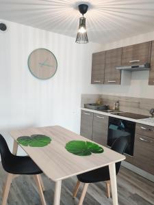 una cucina con tavolo in legno e alcune sedie di Joli appartement avec jardin-terrasse privé a Brest