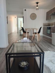 ein Wohnzimmer mit einem Glastisch und Stühlen in der Unterkunft Joli appartement avec jardin-terrasse privé in Brest