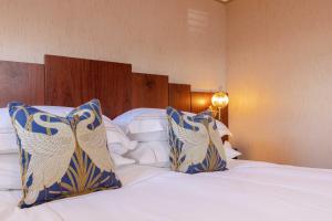 a bedroom with a bed with blue and white pillows at Ocean Mist Leith in Edinburgh
