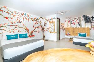 1 dormitorio con 2 camas y un mural de árboles en Ayenda Jardin de Provenza, en Medellín