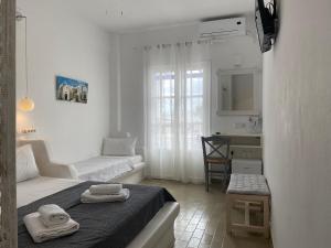 Kleines weißes Zimmer mit einem Bett und einem Waschbecken in der Unterkunft Serene Hill in Naoussa