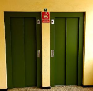 three green garage doors in a building with a sign at Luxury Vista mar y playa Torres del Sol B404 in Playa de las Americas +33 photos