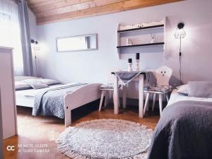 a bedroom with two beds and a desk and a table at Podkowa in Myślenice