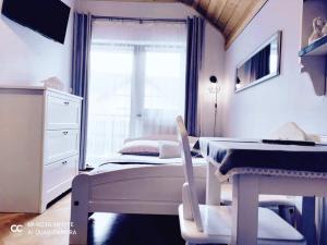 ミシレニツェにあるPodkowaのベッドルーム1室(ベッド1台、デスク、窓付)