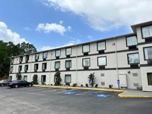 een groot wit gebouw met auto's geparkeerd op een parkeerplaats bij Motel 6-Biloxi, MS - Ocean Springs in Biloxi
