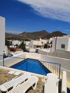a swimming pool with two lounge chairs on a balcony at CASA BLANCA Apartments SAN JOSE in San José