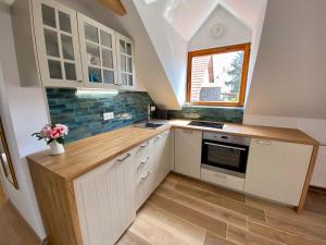 a small kitchen with white cabinets and a window at RÓZSA 19 BADACSONY in Badacsonytomaj