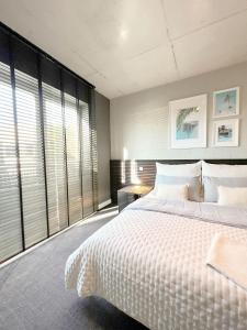 a bedroom with a white bed and large windows at Gossler Suite in Hamburg