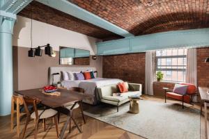 1 dormitorio con 1 cama, mesa y sillas en Native Manchester, en Mánchester
