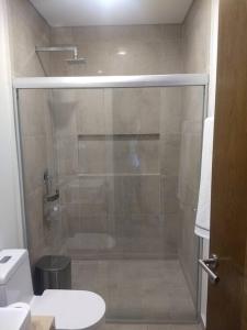 een badkamer met een glazen douche en een toilet bij Nuevo y Lujoso departmento residencial Querétaro. in Querétaro