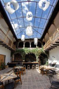 Habitación con mesas, sillas y techo de cristal. en Casa Tunki en Cuzco