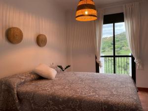 Schlafzimmer mit einem Bett und einem Fenster mit Aussicht in der Unterkunft Suite Rural Oasis in Benamahoma