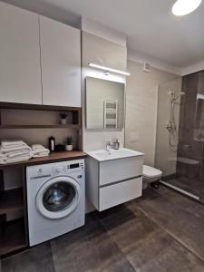 bagno con lavatrice e lavandino di 11th Floor Luxury Residence a Timişoara