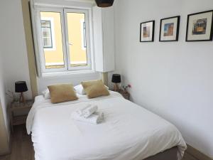 リスボンにあるNew Charming Flat - Lisbon Centerのベッドルーム1室(白いベッド1台、タオル2枚付)