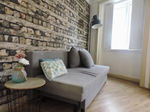 a living room with a brick wall and a couch at New Charming Flat - Lisbon Center in Lisbon