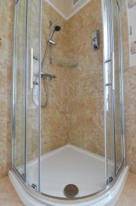 a shower with a glass enclosure in a bathroom at Colbourn Bed and Breakfast in Colwyn Bay