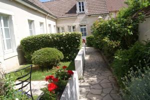 a garden with red flowers and a house at HOTEL LA COGNETTE A 25 Kilomètres de Châteauroux et 30 Kilomètres de Bourges in Issoudun