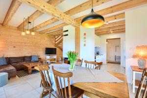 a dining room and living room with wooden ceilings at Słoneczna Solina Bóbrka in Solina