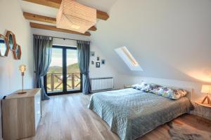 a bedroom with a bed and a large window at Słoneczna Solina Bóbrka in Solina