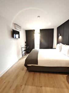 - une chambre avec un grand lit et du parquet dans l'établissement Residencial Douro, à Peso da Régua