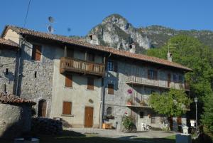 a building with a balcony and a mountain in the background at Bed & Breakfast Castello Regina in Brembilla
