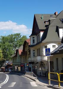 uma rua numa cidade com uma placa de rua e edifícios em Apartament Grzaniec em Szklarska Poręba
