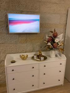 a white dresser with a television on top of it at Appartement im Funkenhöfchen in Pirna