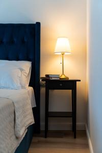 a table with a lamp on it next to a bed at Art Apartments in Zadar