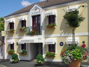 a building with potted plants on the side of it at HOTEL LA COGNETTE A 25 Kilomètres de Châteauroux et 30 Kilomètres de Bourges in Issoudun